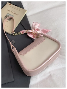 Detailed view of two-tone pink shoulder bag with elegant silk scarf on handle decoration