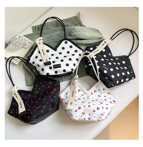Flat lay of tote bags featuring polka dot and cherry patterns with V-shaped openings