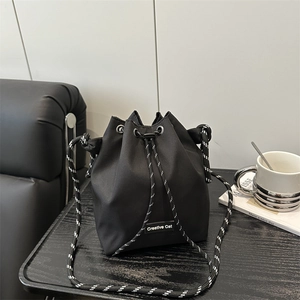 Large black nylon drawstring bucket bag with contrast striped strap and Creative Cat label