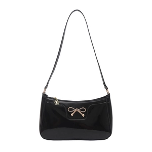 Minimalist black patent leather underarm bag featuring a golden bow and flower charm
