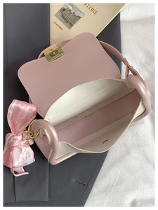 Detail view of pink crossbody bag interior with heart scarf and metal turn-lock closure