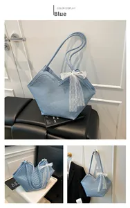 Détail du sac cabas bleu avec nœud en dentelle blanche et coupe en V élégante