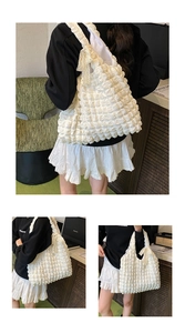Detail of white bubble texture tote bag with lace bow decoration and wide strap