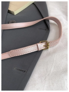 Close-up of pink pearlescent leather strap with golden adjustable metal buckle