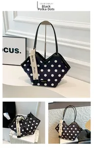 Detail of black tote bag with white polka dots, wave edge and branded decorative strap