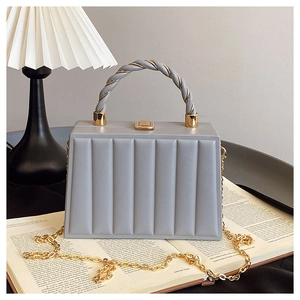 Detail view of wavy textured gray mini handbag with metallic rope handle and gold lock