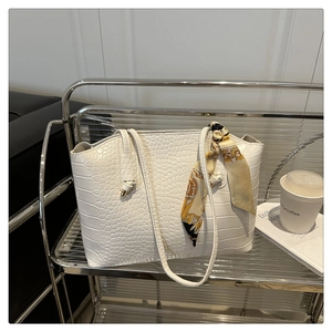 Gros plan du sac cabas blanc à motif crocodile avec un foulard décoratif en soie vintage