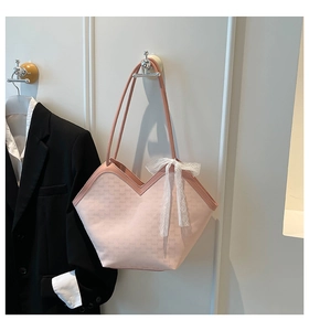 Détail du sac cabas rose avec motif monogramme, coupe en V et grand nœud en dentelle