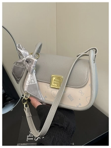 Detail of the chic grey bow scarf accessory and contrast cat print on the flap bag