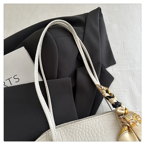 Détail d'un sac cabas blanc à motif crocodile avec un foulard en soie imprimé décoratif