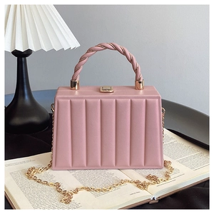 Detail of pink box bag with vertical wave pattern, twisted handle and gold hardware