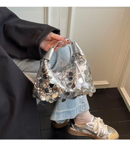 Close-up of silver sequin crescent handbag with beaded fringe detail and metallic handle