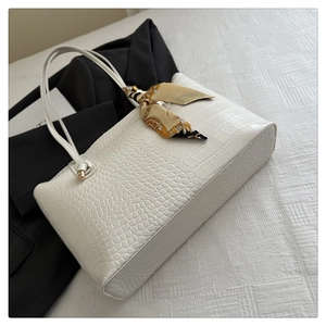 Détail du sac cabas blanc cassé avec motif crocodile et foulard en soie décoratif