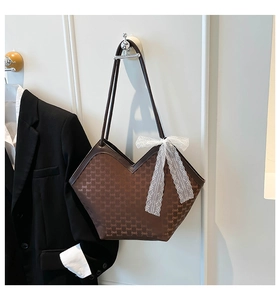 Détail du sac cabas marron foncé avec ouverture en V et nœud en dentelle blanche délicat