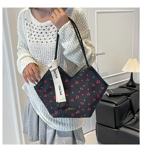 Detail of black cherry print tote bag with a V-cut opening and wide branded strap
