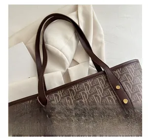 Détail du cabas en toile monogramme vintage avec anses en cuir brun et rivets dorés