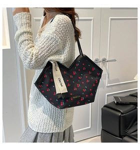 Detail of cherry pattern tote bag with V-cut opening and branded cotton webbing strap