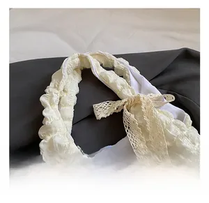 Detail of puffy pleated fabric texture with beige lace bow on off-white tote bag