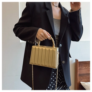 Close-up of gold evening clutch with vertical ridges and metallic top handle