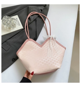 Détail du sac cabas rose avec col en V, lettrage doré et nœud en dentelle blanche