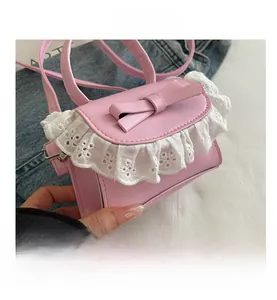 Detail of pink mini handbag featuring a sweet bow and white lace trim on the flap edge