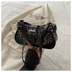 Detail of leopard print fabric and black leather strap with bold stitching on the bag