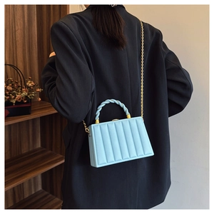 Close-up of light blue rectangle bag with vertical stripes and golden chain strap