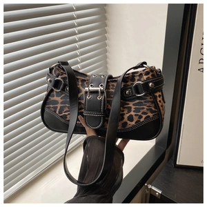 Detail of leopard print crossbody bag with black leather trim and silver metal buckle