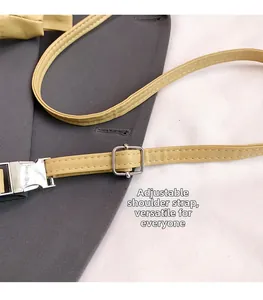 Detailed macro view of the light yellow leather adjustable shoulder strap with silver buckle