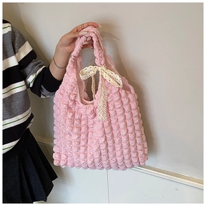 Détail du sac cabas rose à texture gaufrée avec un nœud en dentelle crème élégant