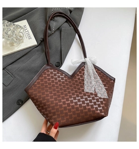 Détail d'un sac cabas jacquard marron en forme de cœur avec un nœud en dentelle