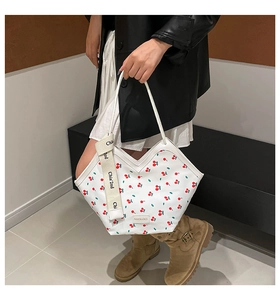 White bucket bag with cherry print shown with model outfit for casual fashion style