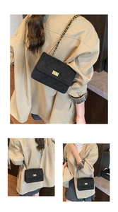 Detail of black quilted leather crossbody bag with gold chain and metal twist lock