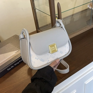 Fashionable color-block crossbody bag with bow pendant and elegant cartoon print detailing
