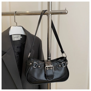 Detail of black PU leather baguette bag with silver hardware on a metal rack