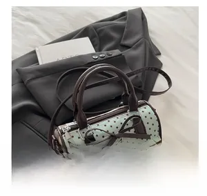 Detailed shot of star print handbag with brown bow accent and pleated trim on grey blazer