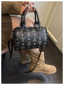Detail of black Boston bag featuring white bear prints and double leather top handles