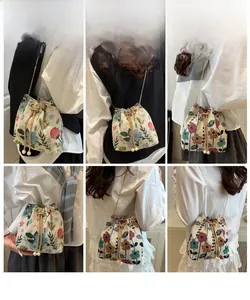 Multi-angle view of floral embroidery bucket bag with gold chain and pearl drawstring