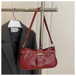 Detail of brick red leather underarm bag featuring silver eyelets and buckle accents