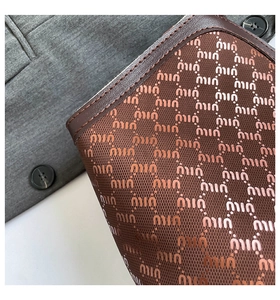 Gros plan sur la texture du sac cabas en cuir marron avec motifs et coutures soignées