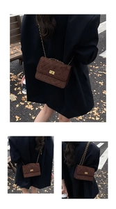 Macro detail of brown quilted suede texture and gold turn-lock on the chain crossbody bag