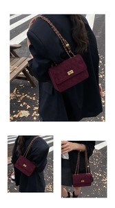 Close-up of wine red velvet quilted bag with golden twist lock and chain strap detail