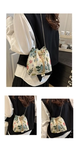 Detail view of retro floral drawstring bucket bag with pearl accents and chain strap
