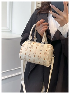 Detail view of mini Boston bag featuring bear monogram pattern and top handles