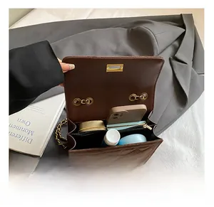 Internal view of brown quilted crossbody bag showing spacious compartments with phone and makeup