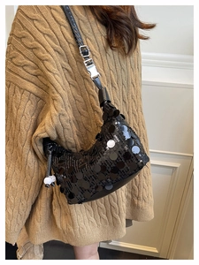 Detail of black sequin underarm bag showing large round sequins and adjustable silver buckle