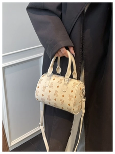 Detail of cream Boston bag with teddy bear pattern and adjustable shoulder strap