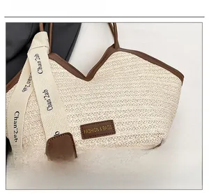 Detail view of woven straw tote bag with brown leather trim and branded logo patch