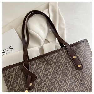 Detail of vintage tote bag featuring FAS LOU monogram print and brown leather handle