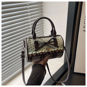 Detailed view of cylindrical bag with star patterns, lace bow, and checkered texture